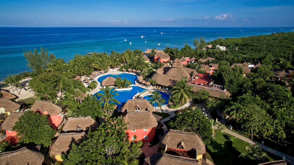 Iberostar Cozumel all-inclusive resort with bungalow-style rooms, tropical landscaping, and beachfront setting.