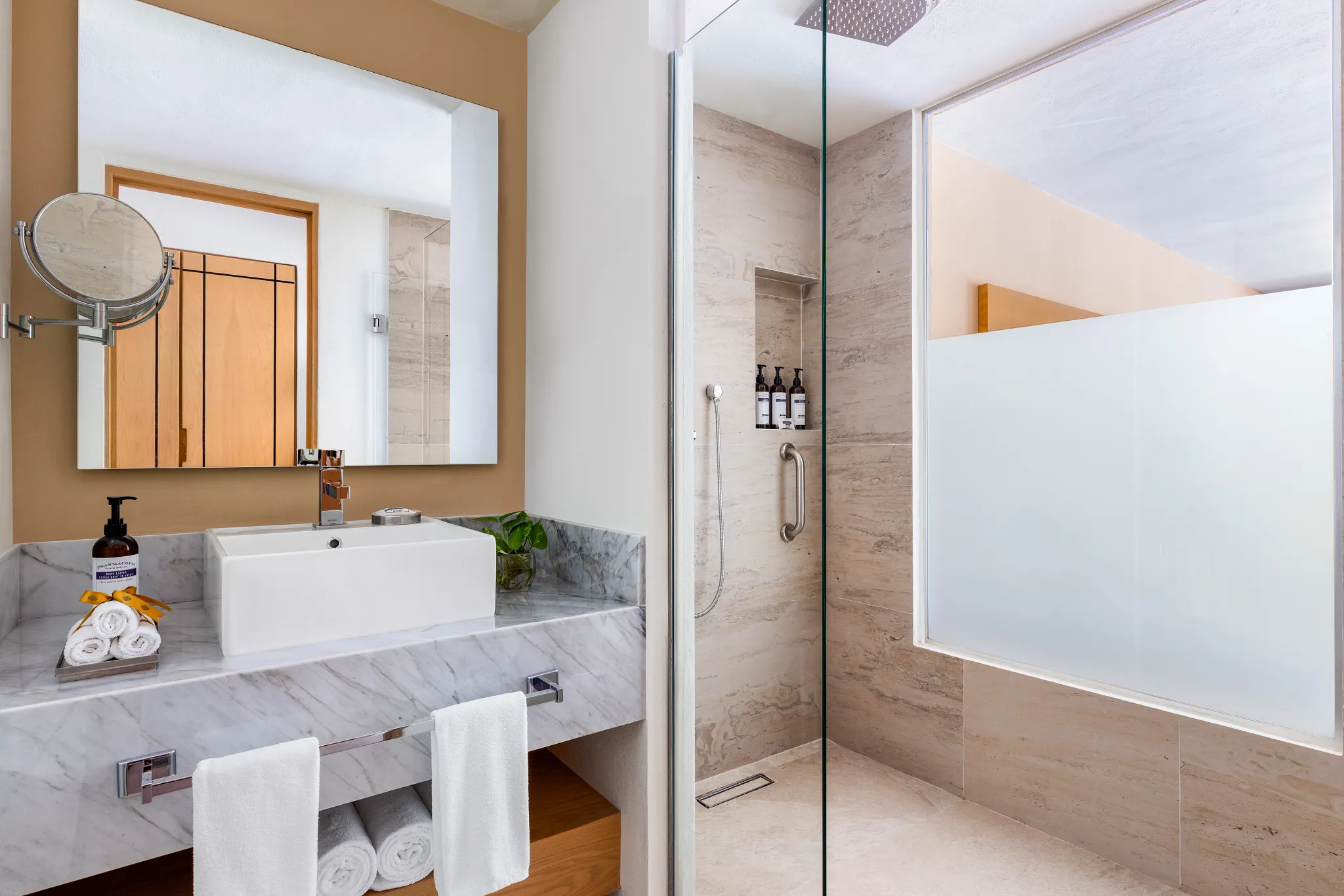Junior Suite bathroom with modern sink and glass walk-in shower at Secrets Aura Cozumel.