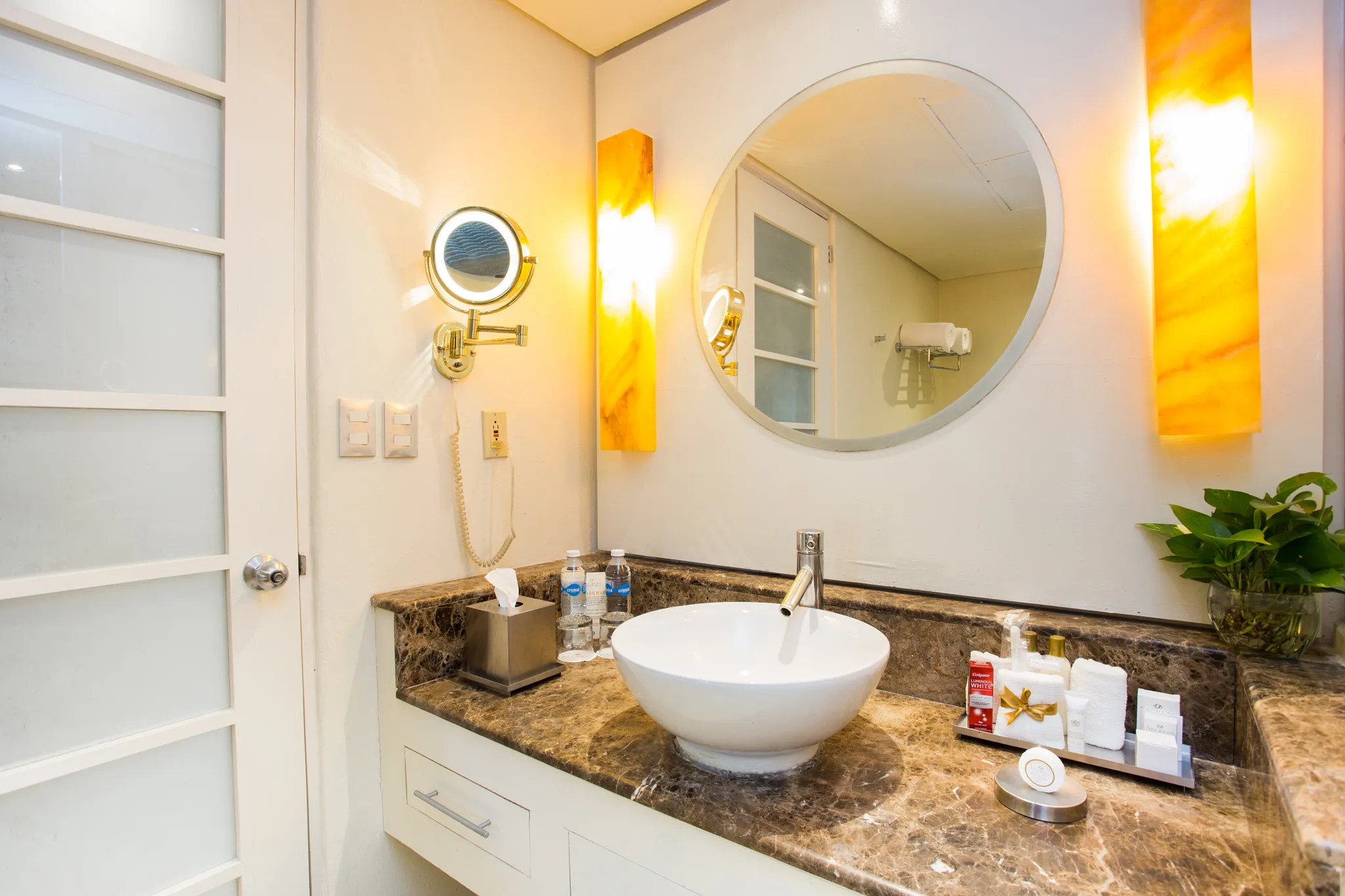 Junior Suite Swim-Up Ocean View vanity with round mirror and marble countertop at Secrets Aura Cozumel.
