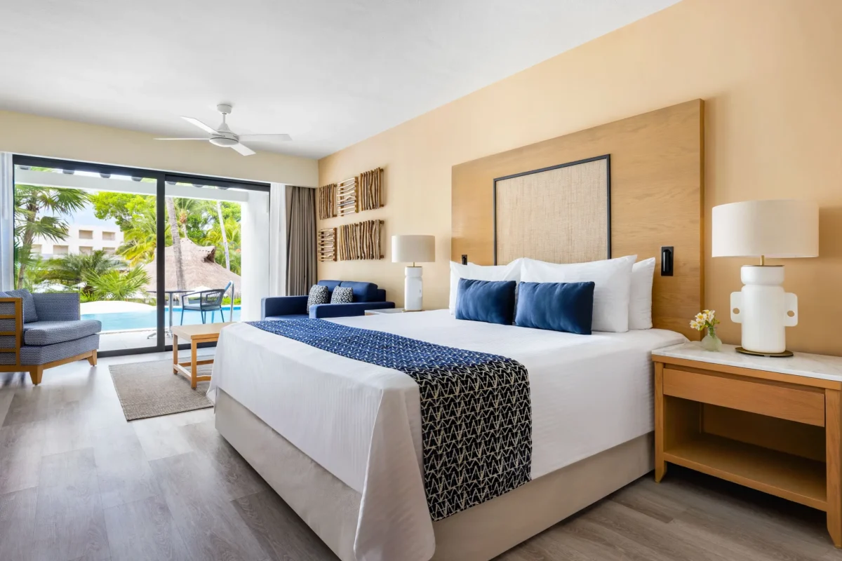 Junior Suite Swim-Up Pool View king bedroom with terrace access at Secrets Aura Cozumel.