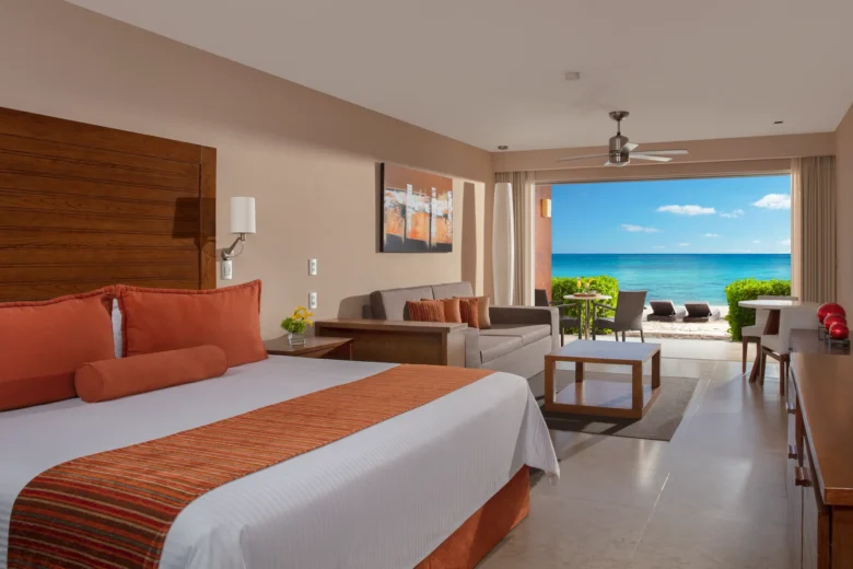 Preferred Club Junior Suite Beachfront with king bed and private terrace overlooking the ocean at Secrets Aura Cozumel.