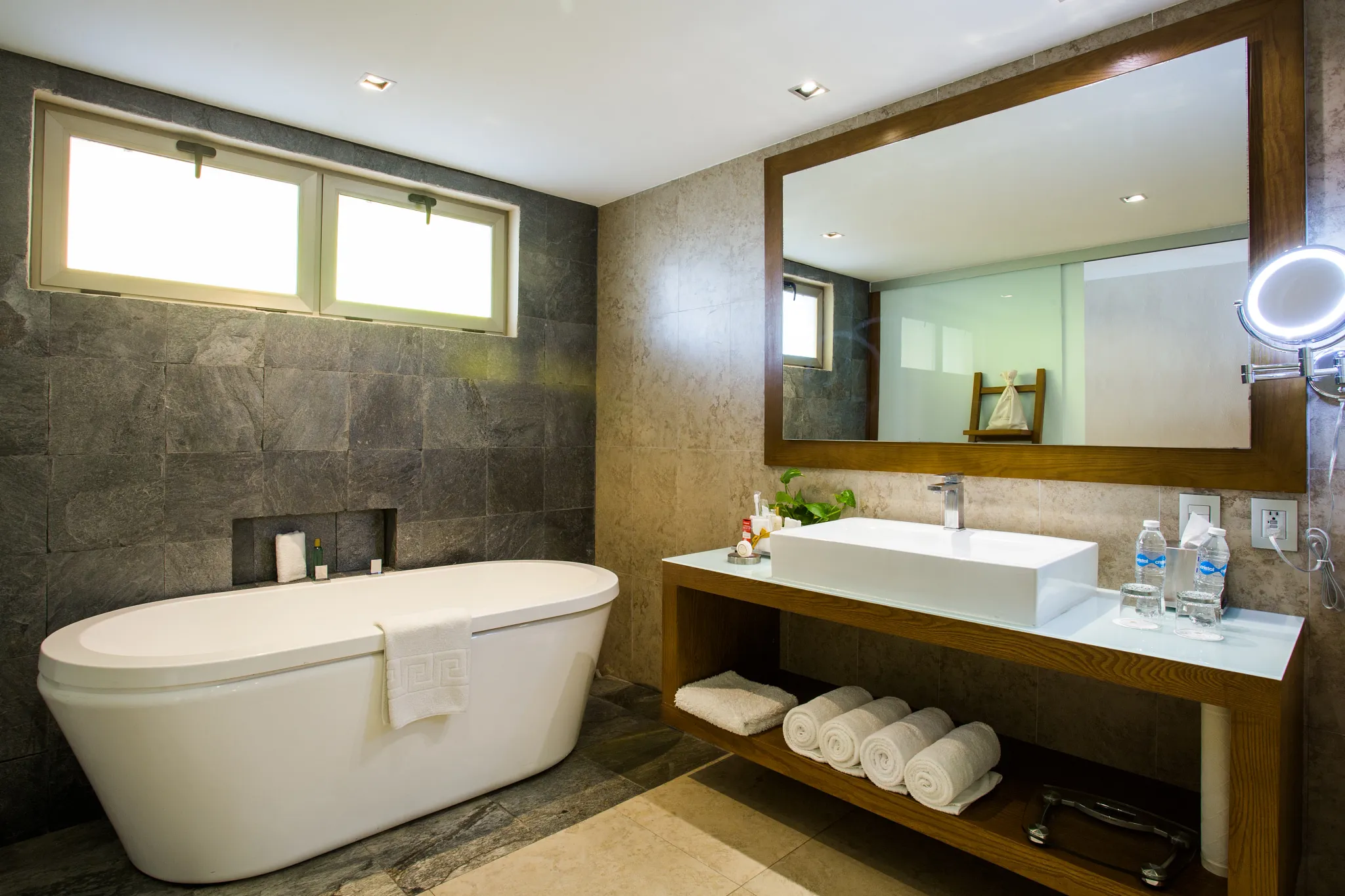 Preferred Club Junior Suite Ocean Front bathroom with freestanding tub and modern vanity at Secrets Aura Cozumel.