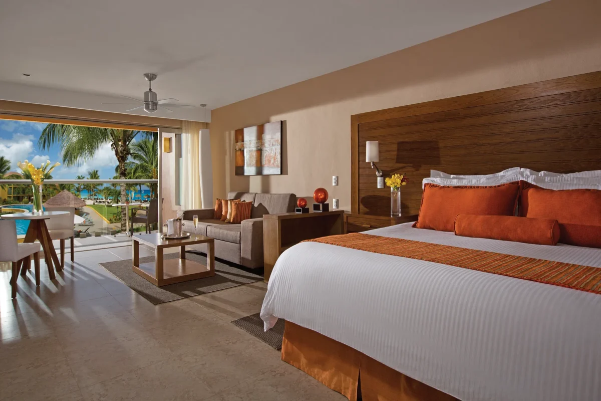 Preferred Club Junior Suite Ocean View with king bed, seating area, and balcony overlooking the ocean at Secrets Aura Cozumel.