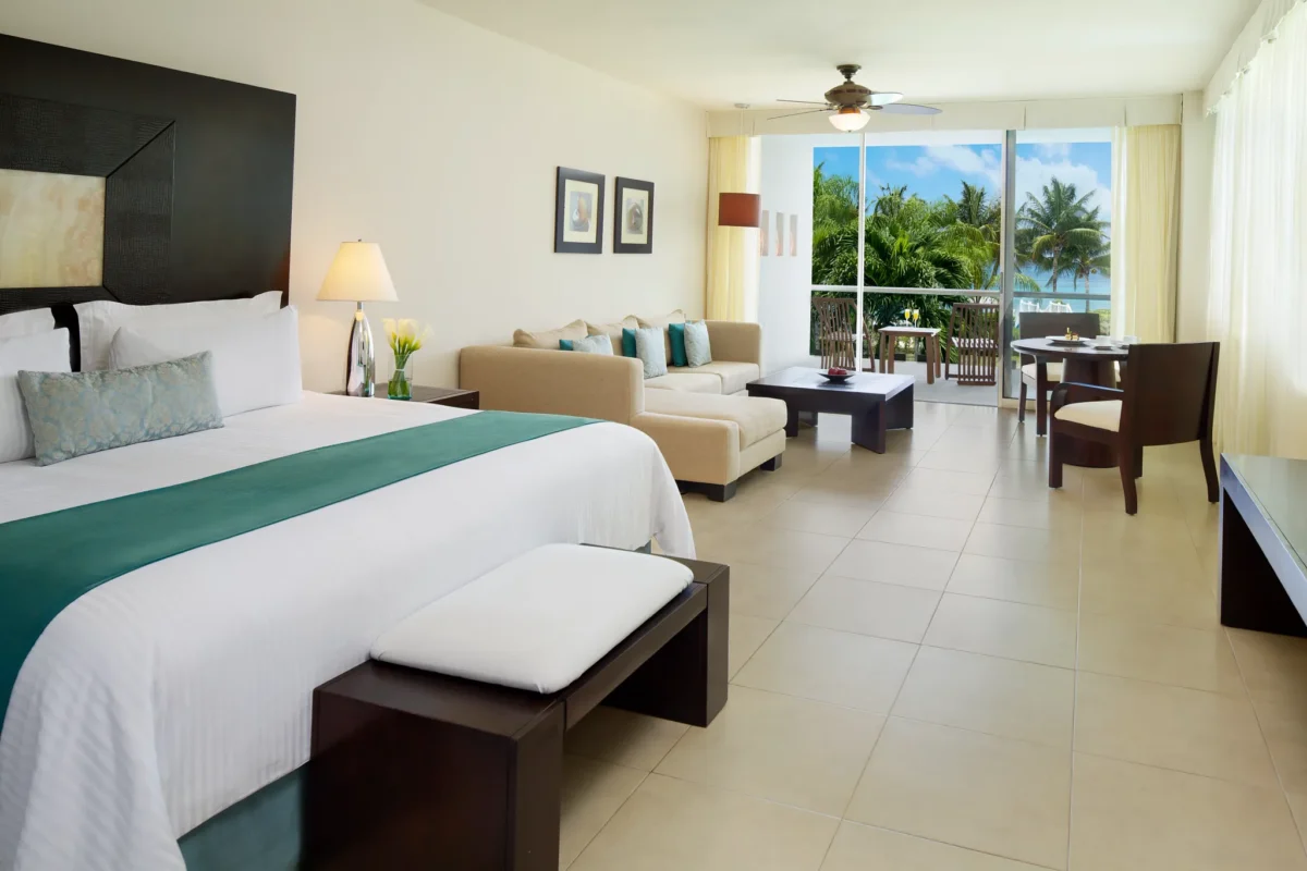Preferred Club Junior Suite Panoramic Ocean View with king bed, living area, and private balcony at Secrets Aura Cozumel.