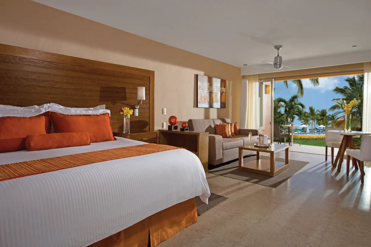 Preferred Club Junior Suite with king bed and terrace overlooking the pool at Secrets Aura Cozumel.