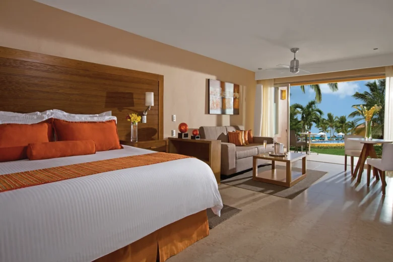 Preferred Club Junior Suite with king bed and terrace overlooking the pool at Secrets Aura Cozumel.