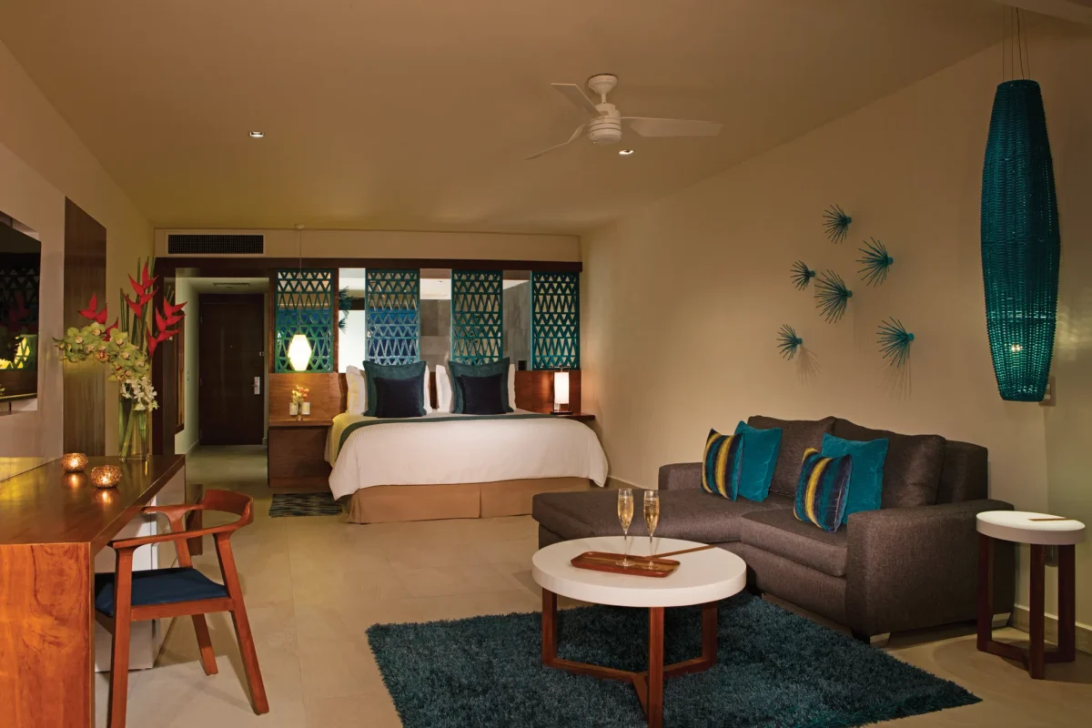 Preferred Club Superior Junior Suite Ocean View with king bed and sitting area at Secrets Aura Cozumel.