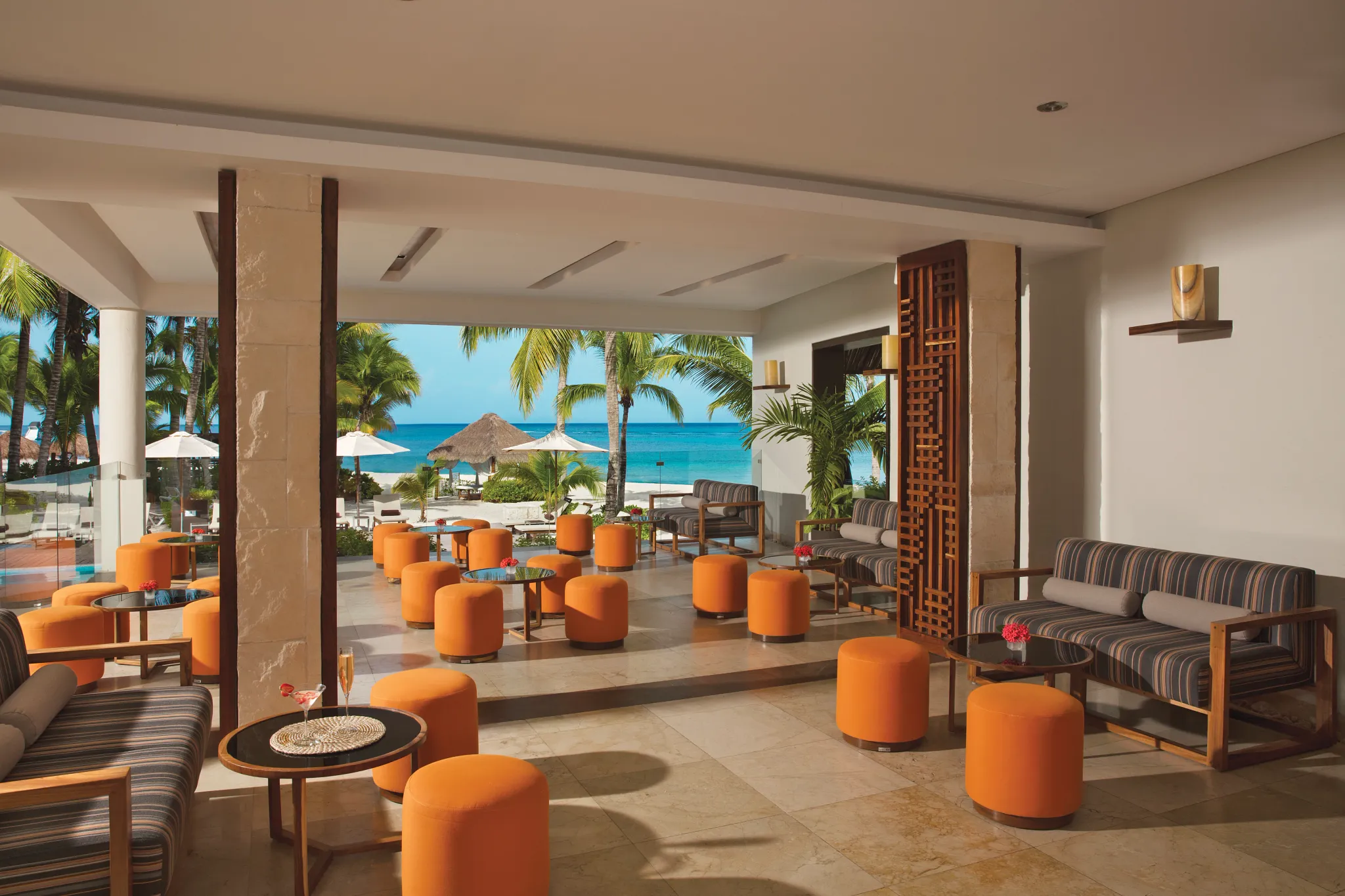 Rendezvous Lobby Bar at Secrets Aura Cozumel featuring elegant seating, Caribbean views, and a stylish bar serving premium liquors.