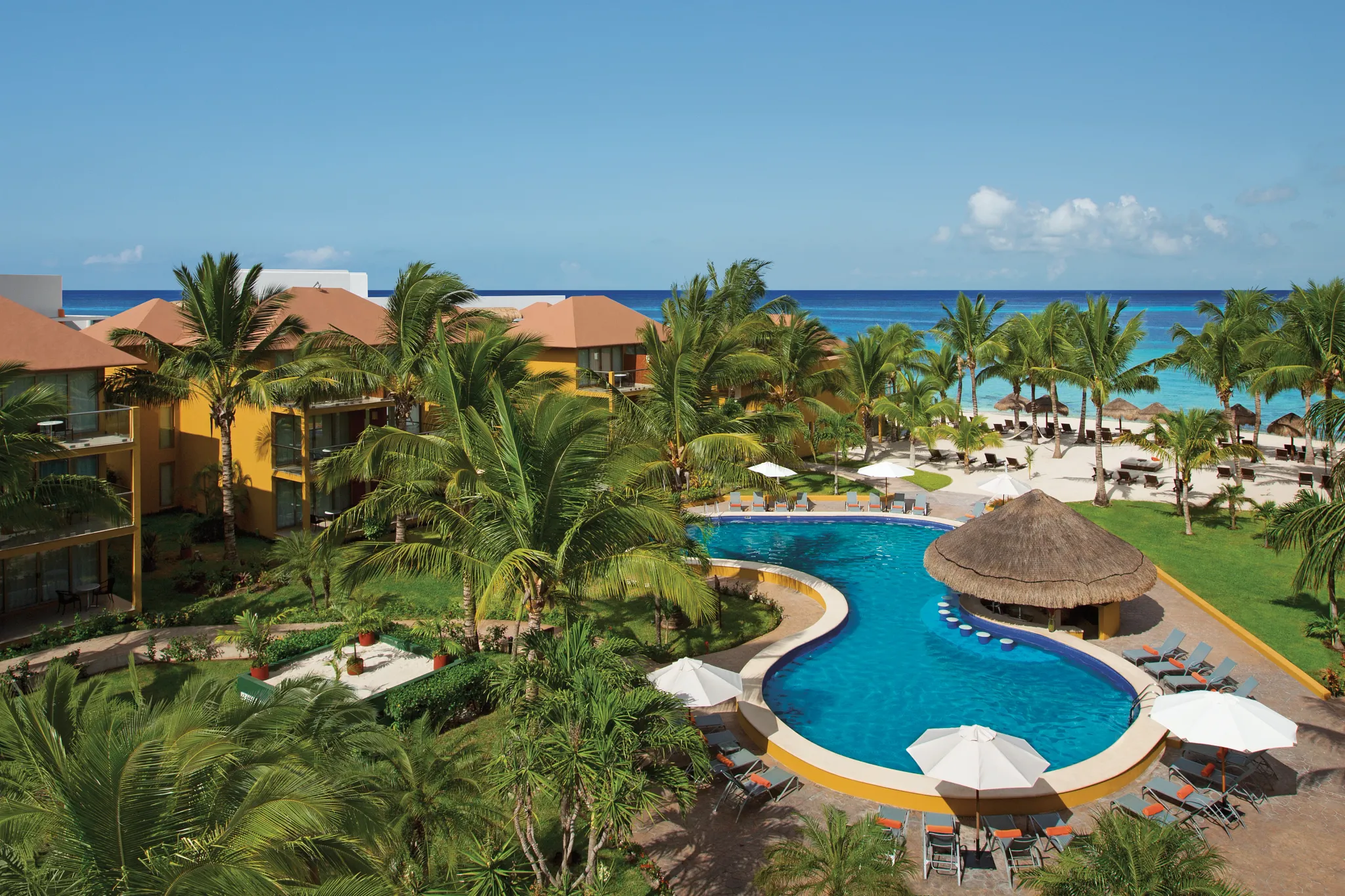 Preferred Club pool with loungers and umbrellas overlooking the Caribbean Sea at Secrets Aura Cozumel.