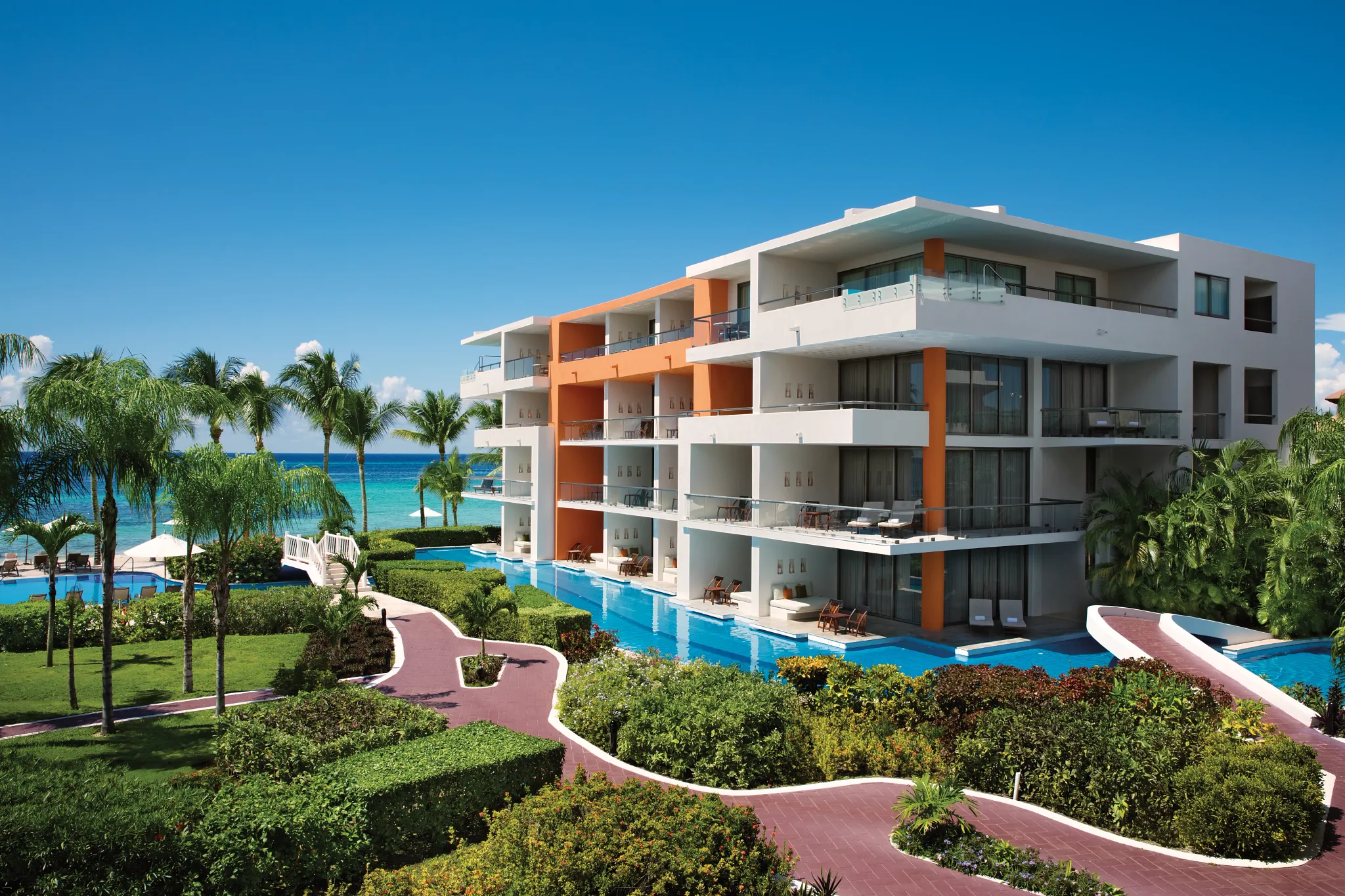 Modern swim-out suites at Secrets Aura Cozumel with pool access, balconies, and tropical gardens.