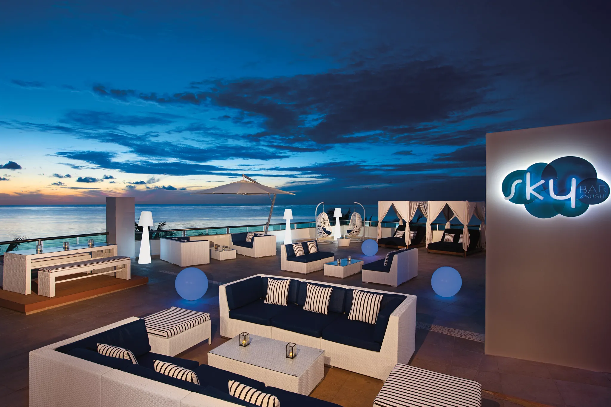 Sky Bar rooftop restaurant at Secrets Aura Cozumel featuring panoramic ocean views, sunset cocktails, and open-air lounge seating.