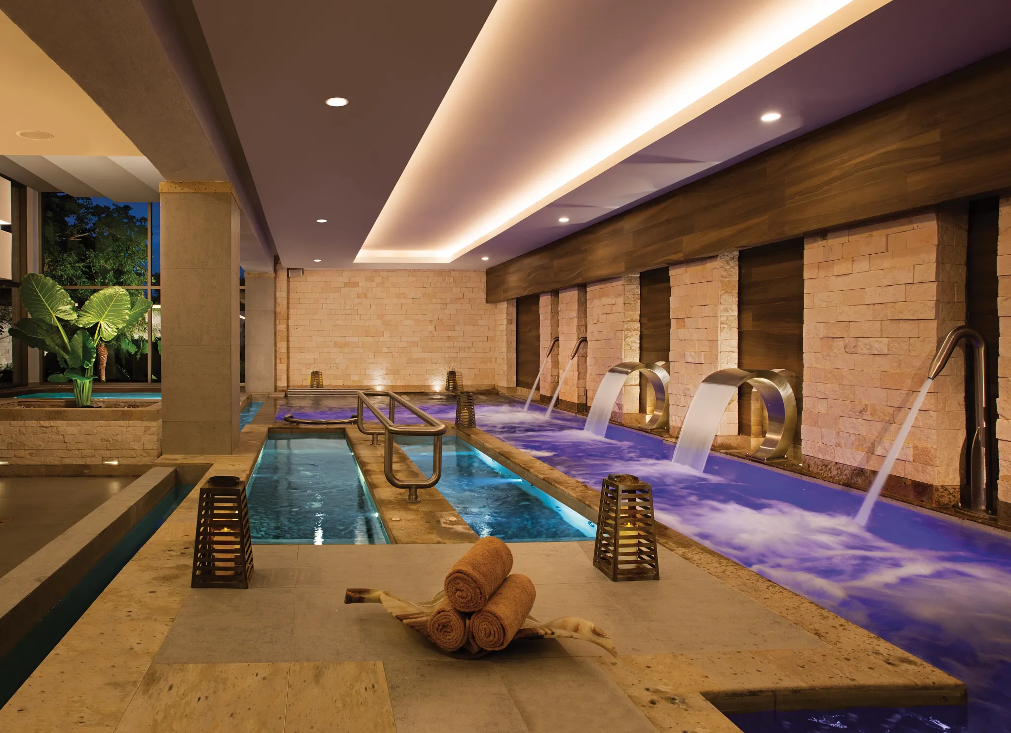 Luxury spa jacuzzi room with candles and ambient lighting at Secrets Aura Cozumel.