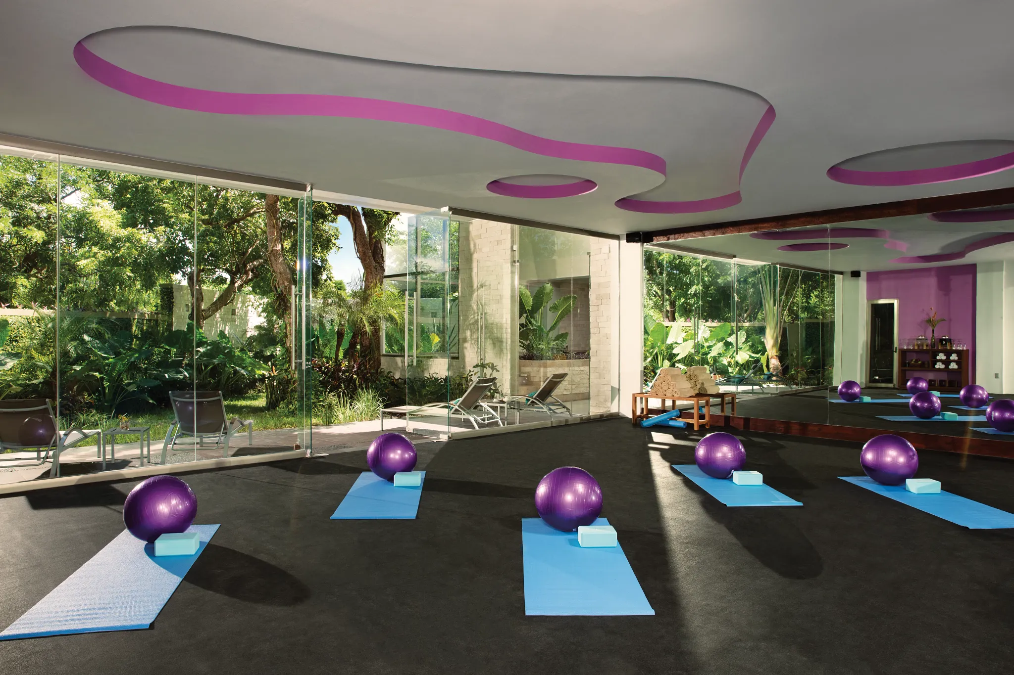 Bright yoga studio with mats and exercise balls at Secrets Aura Cozumel, ideal for wellness and fitness sessions.